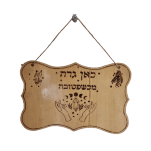 שלט עץ מעוצב בעבודת יד בפירוגרפיה עם הכיתוב כאן גרה